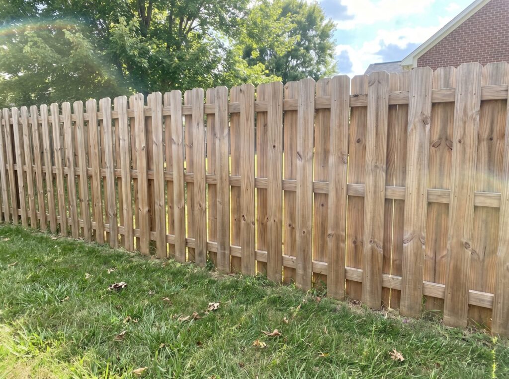 Shadowbox wood fence with alternating boards that let wind pass through